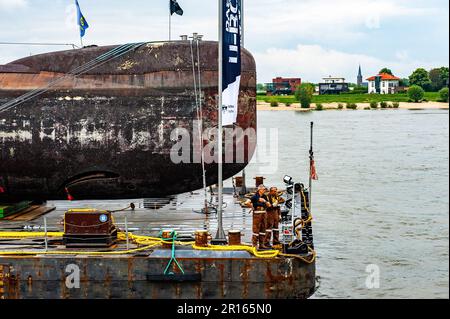 Nijmegen, Paesi Bassi. 11th maggio, 2023. I tecnici della Marina si vedono pronti ad ancorare il pontone galleggiante. Il sottomarino della Marina tedesca del U17 si caricò su un pontone galleggiante, navigando attraverso il paese passando e trascorrendo la notte a Nijmegen, al Waalkade. Con 500 tonnellate e una lunghezza di 50 metri e un'altezza di 9 metri, il sottomarino che partì da Kiel in aprile sarà poi assegnato un posto temporaneo di fronte al Museo della tecnica Speyer, in Germania. Credit: SOPA Images Limited/Alamy Live News Foto Stock