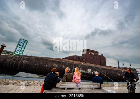 Nijmegen, Paesi Bassi. 11th maggio, 2023. Una famiglia si vede seduta davanti al sottomarino. Il sottomarino della Marina tedesca del U17 si caricò su un pontone galleggiante, navigando attraverso il paese passando e trascorrendo la notte a Nijmegen, al Waalkade. Con 500 tonnellate e una lunghezza di 50 metri e un'altezza di 9 metri, il sottomarino che partì da Kiel in aprile sarà poi assegnato un posto temporaneo di fronte al Museo della tecnica Speyer, in Germania. (Foto di Ana Fernandez/SOPA Images/Sipa USA) Credit: Sipa USA/Alamy Live News Foto Stock