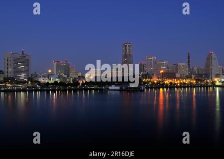 Grattacieli e Minato Mirai Yokohama Port su una luna piena come visto dal molo di Osanbashi Foto Stock