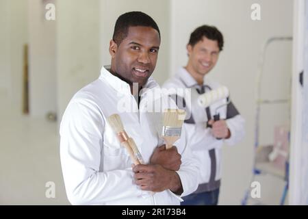 pittore che tiene un campione di colore e un rullo di vernice Foto Stock