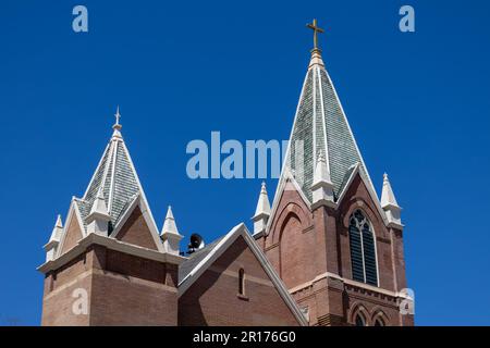Vista dall'alto di una torre campanaria su una chiesa americana del 19th ° secolo in stile gotico Revival architettura, con sfondo cielo blu Foto Stock