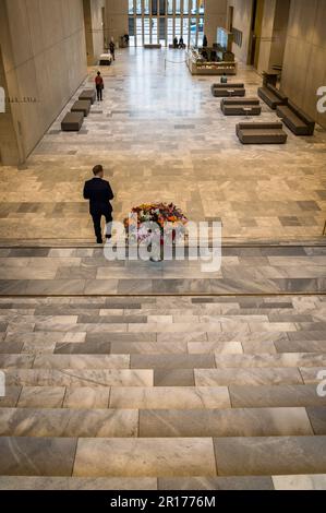 Uomo che cammina lungo la grande scala passando un vaso di fiori enorme, Kunsthaus, Museo d'Arte, nuovo edificio, Zurigo, Svizzera Foto Stock