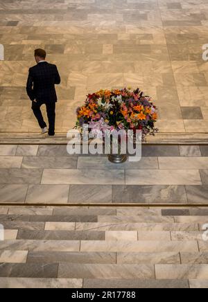 Uomo che cammina lungo la grande scala passando un vaso di fiori enorme, Kunsthaus, Museo d'Arte, nuovo edificio, Zurigo, Svizzera Foto Stock