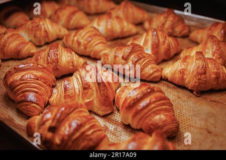 Un primo piano di croissant appena sfornati su un vassoio Foto Stock