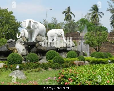 Thailandia, Chiang mai: Elefanti modello su un'isola di traffico, con Ku Ruang angolo del muro della città sullo sfondo. Foto Stock