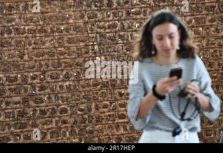 Roma, Italia. 11th maggio, 2023. Una donna passa davanti alla scultura 'Continuum' durante un'anteprima mediatica della mostra 'il Grande Teatro delle civiltà' presso la sede di Fendi a Roma, Italia, il 11 maggio 2023. La mostra, che si svolge dal 12 maggio al 1 ottobre, espone una trentina di opere realizzate dallo scultore italiano contemporaneo Arnaldo Pomodoro tra la fine del 1950s e il 2021, insieme a una serie di materiali archivistici tra cui fotografie, documenti, schizzi e disegni. Credit: Jin Mamengni/Xinhua/Alamy Live News Foto Stock