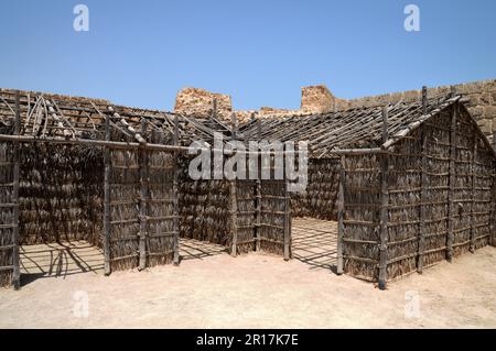 Bahrain, Manama: Fortezza di Qalat al-Bahrain - tradizionali rifugi di foglie di palme da dattero forniscono una certa tregua dal sole all'interno della fortezza. Foto Stock