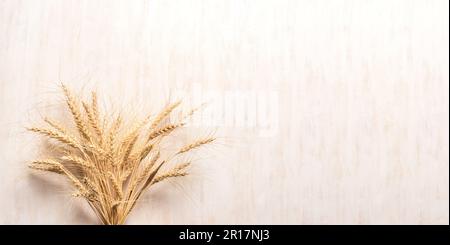 Spighe di grano su sfondo di legno bianco, banner, spazio di copia. Nuovo raccolto e vacanza ebraica Shavuot concetto. Foto Stock