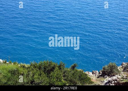 Vista dall'alto dalla costa rocciosa alla superficie dell'acqua azzurra sul mare con piccole onde nelle giornate di sole Foto Stock