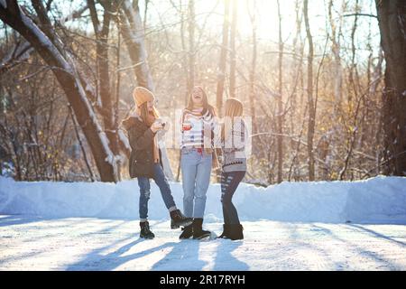 Tre ragazze giovani felici e belle all'aperto nella neve. Foto Stock