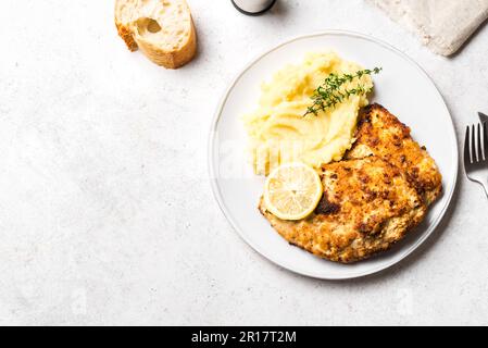 Schnitzel tedesco con purè di patate fresche e timo su sfondo bianco, spazio copia. Trita di carne di maiale impanata fatta in casa. Wiener Schnitzel. Foto Stock