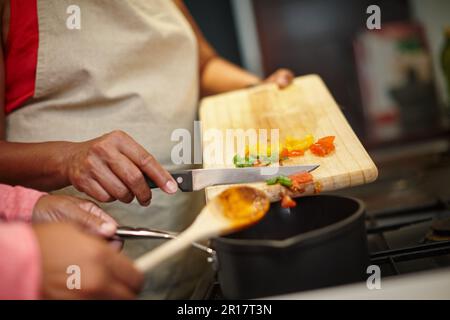 Deliciousness nel fare. Primo piano di due persone che cucinano un pasto insieme a casa. Foto Stock