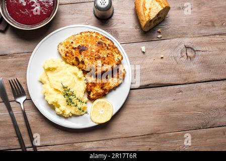 Schnitzel tedesco con purè di patate fresco su legno, spazio copia. Trita di carne di maiale impanata fatta in casa. Wiener Schnitzel. Foto Stock