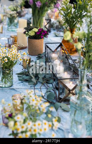 Candele e disposizione dei fiori per la disposizione della tabella di nozze Foto Stock