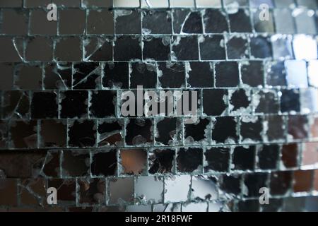 Una grande piastrella a mosaico a specchio utilizzata per la decorazione delle pareti è rotta da crepe. Specchi realistici. Superficie quadrata in vetro riflettente. Foto di alta qualità Foto Stock