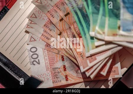 Sparse varie banconote di diversi tagli in valuta zloty polacca su un taccuino. Il concetto di aumento della spesa e del sostegno economico Foto Stock