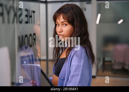 Bella lavoratrice in piedi all'ingresso della camera Foto Stock