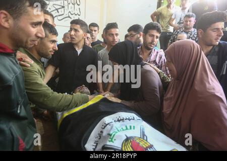 Beit Hanoun, territori palestinesi. 12th maggio, 2023. I parenti piangono il martire Abdel Halim al-Najjar, ucciso in uno sciopero aereo israeliano, durante il suo funerale. Credit: Mohammed Talatene/dpa/Alamy Live News Foto Stock