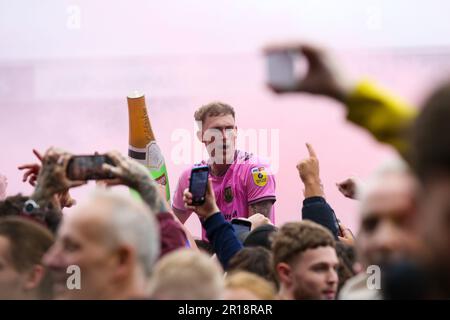 Mitch Pinnock di Northampton Town festeggia con i tifosi in campo dopo aver ottenuto la promozione dopo la partita della Sky Bet League Two al Prenton Park, Birkenhead. Data immagine: Lunedì 8 maggio 2023. Foto Stock