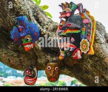 Belle maschere tradizionali in legno scolpito Sri Lanka appese su un albero Foto Stock