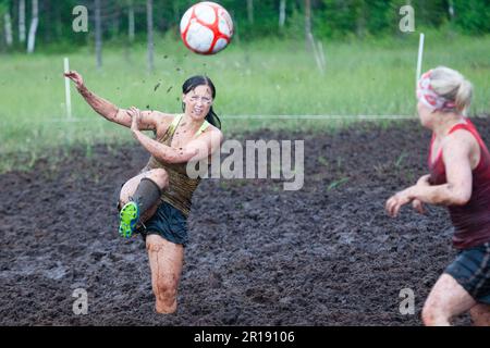 SWAMP SOCCER, FINLANDIA, 2014: L'annuale Swamp Soccer World Championship 2014 a Ukkohalla a Hyrnsalmi, Finlandia. Fotografia: Rob Watkins. INFO: Swamp Soccer è un fenomeno sportivo bizzarro e fangoso. Giocata su terreni boggy, questo adattamento del calcio aggiunge un tocco di divertimento. I partecipanti si divertono nel caos, trasformando uno sport tradizionale in un'esperienza divertente e memorabile che attira sia giocatori che spettatori. Foto Stock