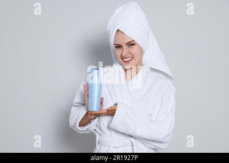 Donna in asciugamano grigio nella doccia con una spazzola per massaggio in legno  per pulire la pelle Foto stock - Alamy