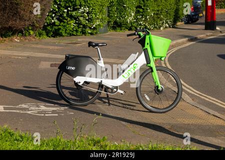 Noleggio Lime noleggio biciclette e bike / bici elettriche e male parcheggiato da un ciclista sulla pista ciclabile marciapiede di una strada / strada a Twickenham, Regno Unito. (134) Foto Stock