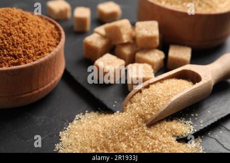 Misurarla con lo zucchero di canna sul tavolo nero, primo piano Foto Stock