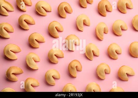 Molti biscotti gustosi della fortuna con le previsioni sullo sfondo rosa, giacimento piatto Foto Stock