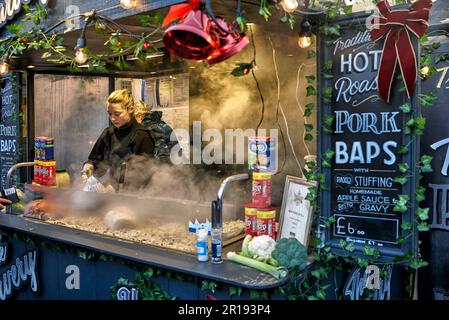 Street food mercato Regno Unito con venditore di braciole di maiale arrosto. Stratford Upon Avon, Warwickshire, Inghilterra, Regno Unito Foto Stock