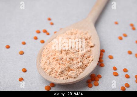 Cucchiaio di farina di lenticchie e semi su tavola bianca, primo piano Foto Stock