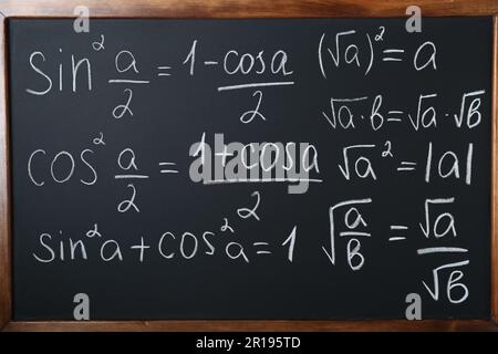 Diverse formule matematiche scritte con il gesso sulla lavagna Foto Stock