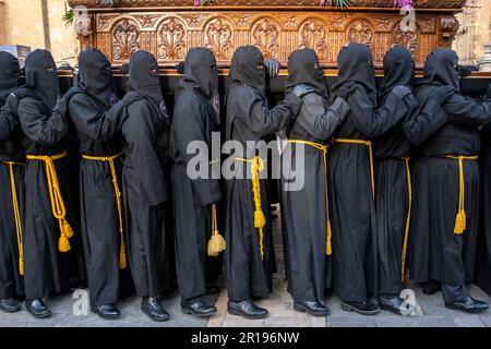 I membri della Confraternita di Gesù nel Sacramento e Santa Maria della Misericordia, Amparo de los Leoneses portano un Paso durante Semana Santa, Leon, Spagna Foto Stock