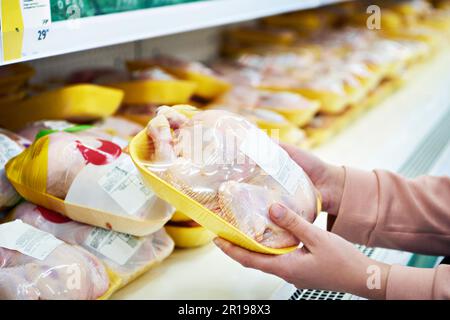 Pollo freddo nelle mani dell'acquirente nel negozio Foto Stock