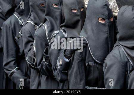 I membri della Cofradía del Cristo del Gran Poder portano un Paso durante una processione di Semana Santa a Leon, Spagna Foto Stock