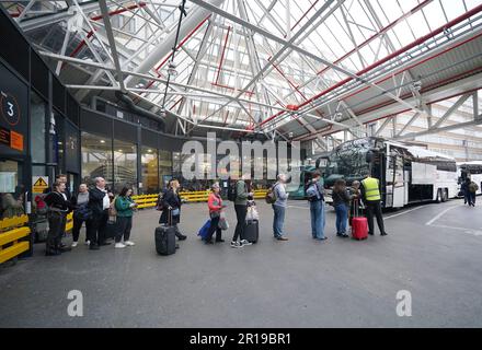 Alcuni dei tifosi che si trovano in coda per salire a bordo di un pullman per Liverpool presso la Victoria Coach Station, nel centro di Londra, per partecipare alla finale dell'Eurovision Song Contest. Data immagine: Venerdì 12 maggio 2023. Foto Stock