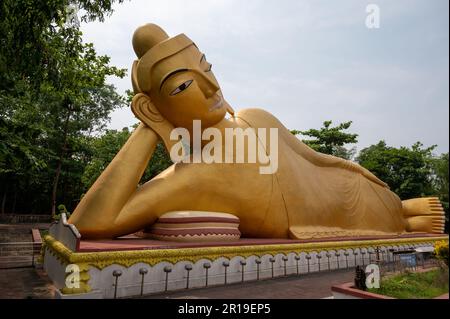 Statua reclinata di 100 metri di colore dorato del Buddha, situata presso il tempio Vimukti Bibeshan Bhabna Kendra, Cox's Bazar, Bangladesh Foto Stock