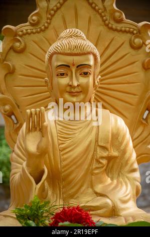 Statua di Buddha seduto color oro al tempio Vimukti Bibeshan Bhabna Kendra situato a Ramu vicino al Cox's Bazar, Bangladesh Foto Stock