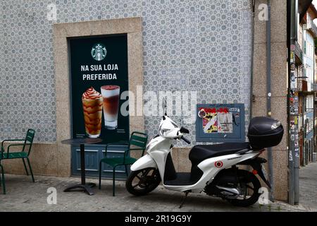 Scooter bianco Honda Vision 110 parcheggiato sulla strada laterale accanto al caffè Starbucks in Praca da Liberdade, Porto / Porto, Portogallo Foto Stock