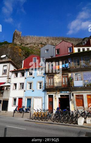 Noleggio biciclette parcheggiate di fronte agli edifici su Av Gustavo Eiffel, vecchie mura di Muralha Fernandina sullo sfondo, quartiere Ribeira, Porto / Oporto, Por Foto Stock