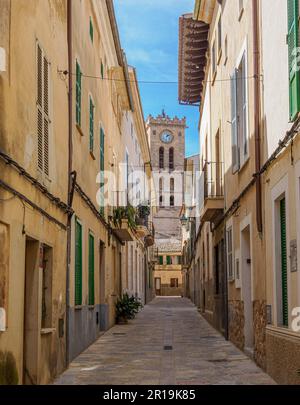 Strada stretta e torre della chiesa nella graziosa cittadina di Pollenca, nei Monti Tramuntana di Maiorca, Spagna Foto Stock