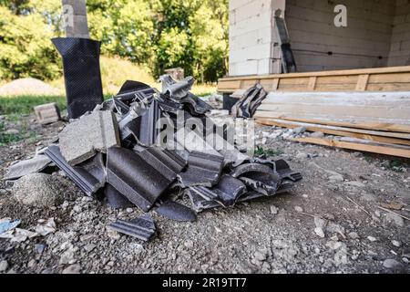 Residui industriali - rimangono dalle tegole del tetto sul terreno in cantiere Foto Stock