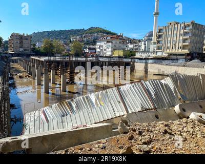 Costruzione di un edificio a telaio monolitico, fondazione non finita con colonne in cemento armato in cantiere con fossa allagata. Foto Stock