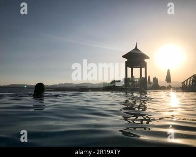 Cabina di salvataggio, torre, posto di salvataggio sul bordo della piscina-infinity acqua che si fonde con l'orizzonte sullo sfondo del mare in un mare tropicale re Foto Stock