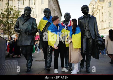 I tifosi che mettono una bandiera Ukrainan sulla Statua dei Beatles a Pier Head a Liverpool in vista della finale dell'Eurovision Song Contest alla M&S Bank Arena di sabato. Data immagine: Venerdì 12 maggio 2023. Foto Stock