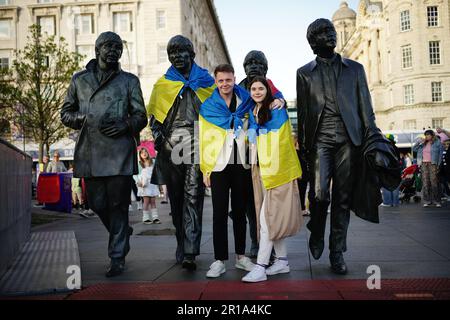I tifosi che mettono una bandiera Ukrainan sulla Statua dei Beatles a Pier Head a Liverpool in vista della finale dell'Eurovision Song Contest alla M&S Bank Arena di sabato. Data immagine: Venerdì 12 maggio 2023. Foto Stock