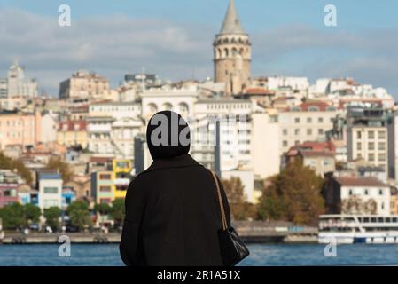 Istanbul, Turchia. 9th Nov 2022. Una donna musulmana si affaccia sul Corno d'Oro verso la torre Galata sul lato europeo di Istanbul. (Credit Image: © John Wreford/SOPA Images via ZUMA Press Wire) SOLO PER USO EDITORIALE! Non per USO commerciale! Foto Stock