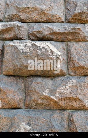 Struttura fatta di grande grande robusta, forte, sollevata, convessa, pietra naturale, granito del muro storto con cuciture e crepe. Lo sfondo. Foto Stock