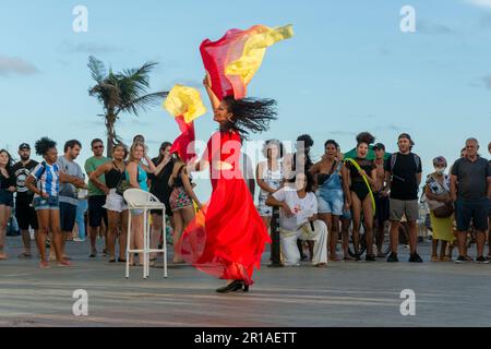 Salvador, Bahia, Brasile - 22 ottobre 2022: Artista di strada che fa una performance di danza per molte persone a Farol da barra, a Salvador, Bahia. Foto Stock