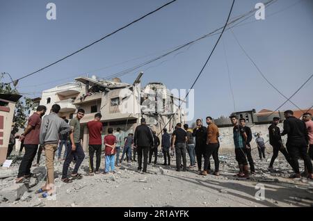 Gaza, Palestina. 12th maggio, 2023. I palestinesi guardano ad una casa distrutta dagli attacchi aerei israeliani a Khan Yunis, nella striscia di Gaza meridionale. (Foto di Yousef Masoud/SOPA Images/Sipa USA) Credit: Sipa USA/Alamy Live News Foto Stock